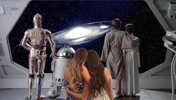 C-3PO, R2-D2 und mehrere Personen blicken aus einem Raumschiff auf eine Galaxie.