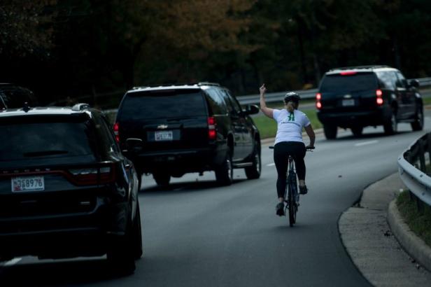 Frau grüßt Trumps Wagenkonvoi mit Mittelfinger