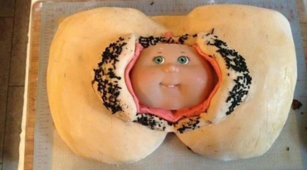 Ein Kuchen in Form einer Geburt mit einem Puppenkopf, der herauskommt.