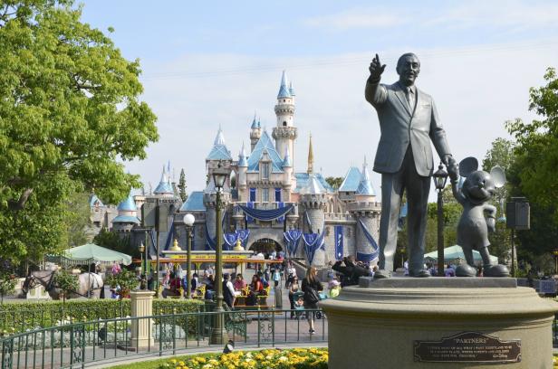 Eine Statue von Walt Disney und Mickey Mouse vor dem Dornröschenschloss im Disneyland Park.
