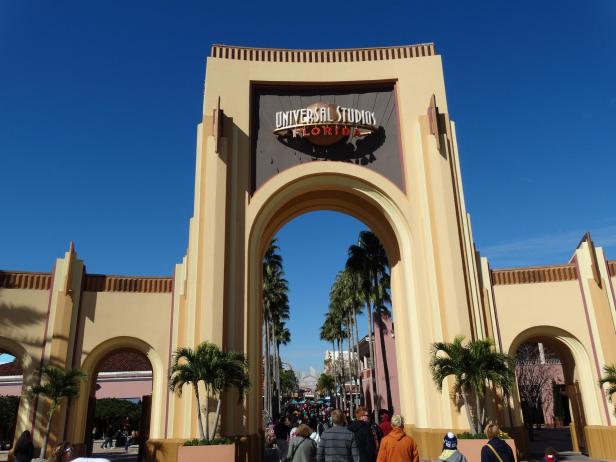 Das Eingangsportal zu den Universal Studios Florida mit Besuchern im Vordergrund.