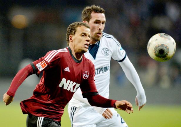 Zwei Fußballspieler während eines Bundesligaspiels im Zweikampf.