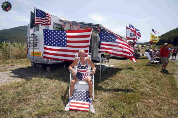 Ein Mann, gekleidet in US-Flaggen-Muster, sitzt vor einem Wohnmobil mit US-amerikanischer Dekoration.