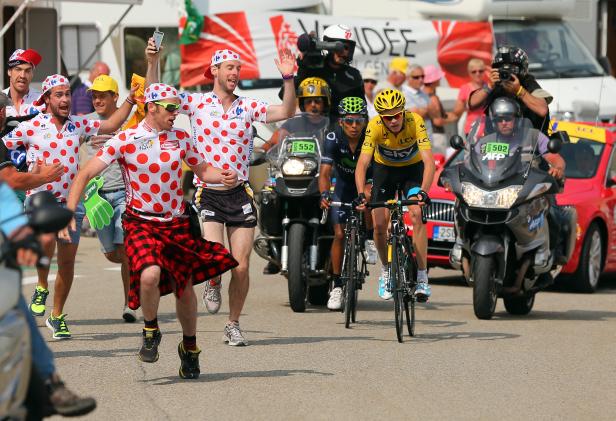 Radfahrer in Gelb und Fans beim Straßenrennen der Tour de France.