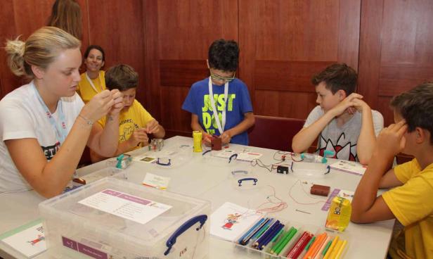 Eine Gruppe Kinder nimmt an einem Workshop zum Thema Elektrizität teil.
