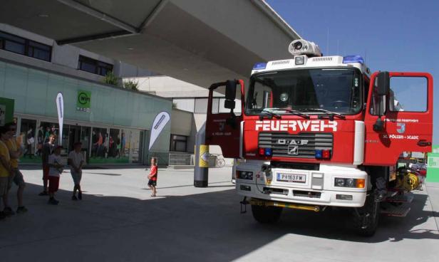 Ein rotes Feuerwehrauto der Freiwilligen Feuerwehr St. Pölten-Stadt steht vor einem Gebäude.