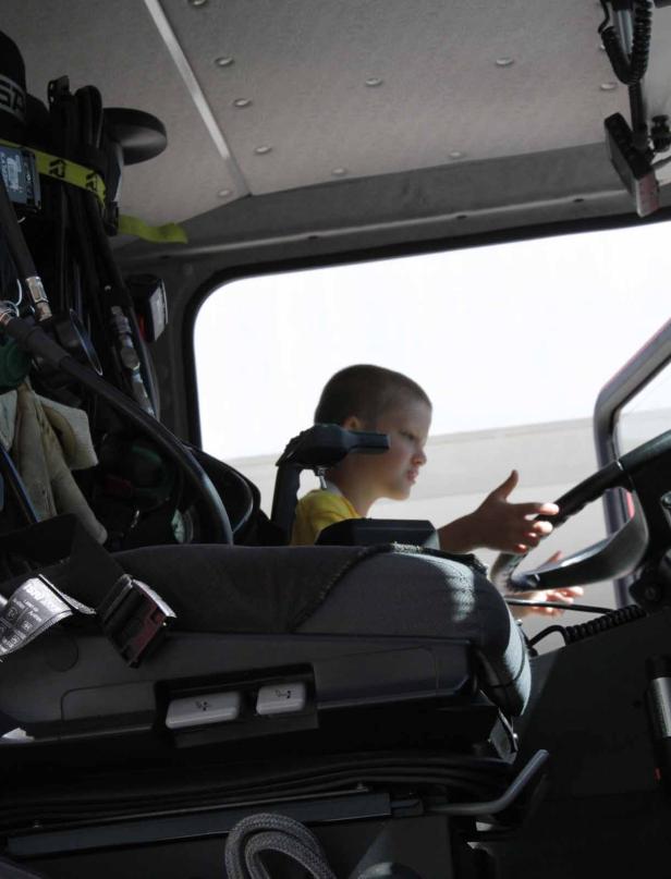 Ein Kind sitzt am Steuer eines großen Fahrzeugs.
