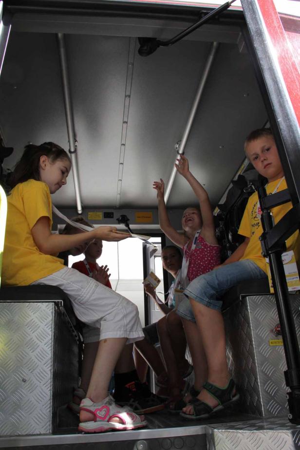 Eine Gruppe Kinder sitzt im Inneren eines Feuerwehrautos.