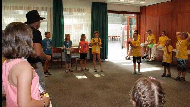 Eine Gruppe Kinder und Erwachsene in einem Raum, einige tragen gelbe T-Shirts.