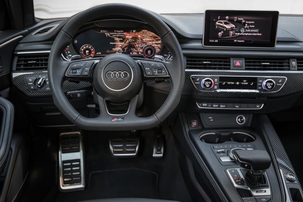 Innenraum eines Audi RS mit Fokus auf Lenkrad, Armaturenbrett und Infotainment-System.