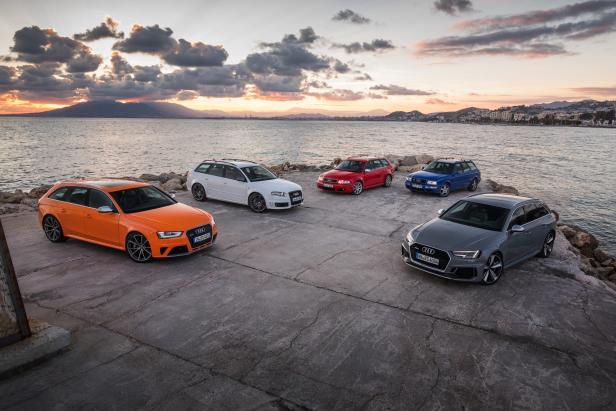 Fünf Audi RS4 Avant Modelle verschiedener Generationen stehen am Ufer bei Sonnenuntergang.