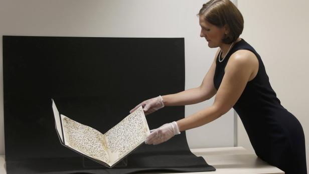 Conservator Marie Sviergula holds a fragment of a