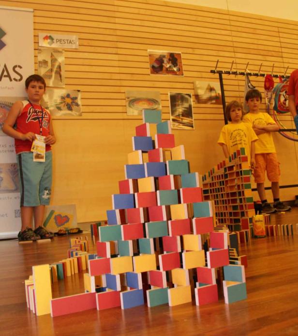 Kinder bauen Türme und Mauern aus bunten Holzbausteinen.
