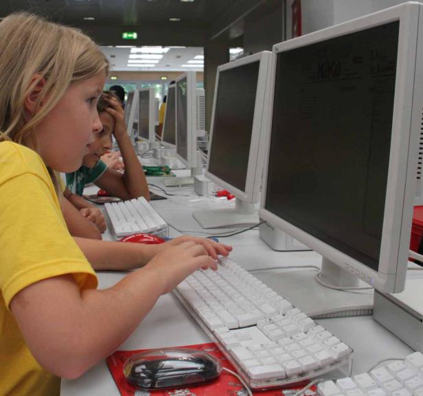 Ein Mädchen tippt an einem Computer in einem Computerraum.
