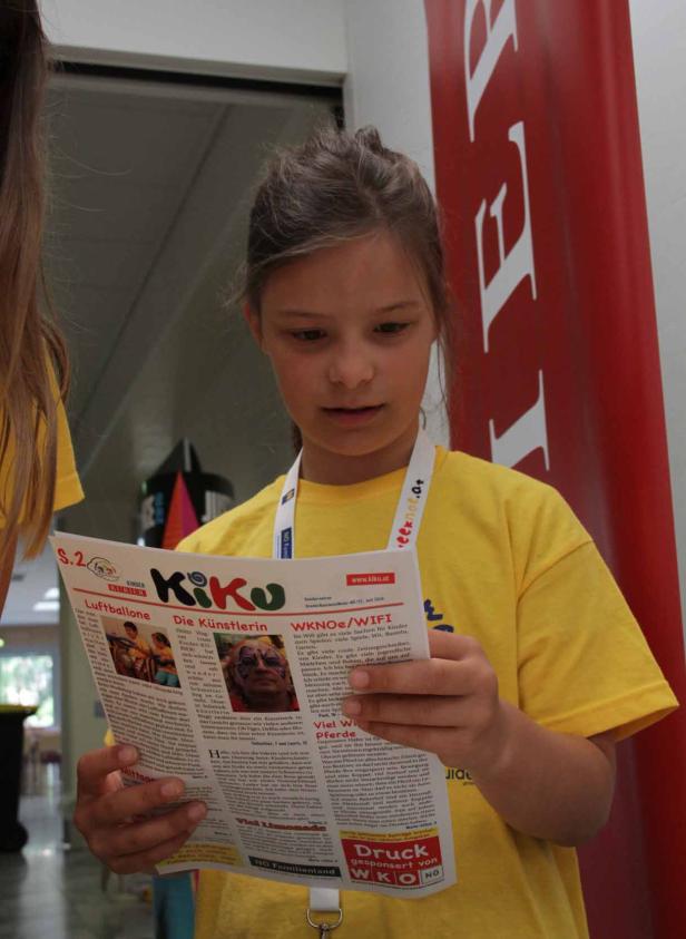 Ein junges Mädchen liest eine Ausgabe des „Kinder Kurier KiKo“.
