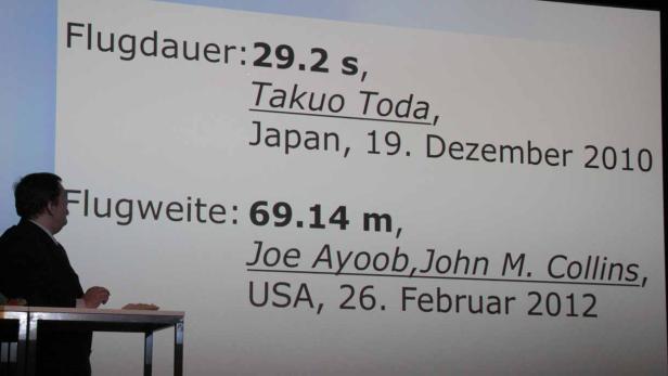 Eine Präsentation zeigt die Flugdauer von 29,2 s durch Takuo Toda (Japan, 19. Dezember 2010) und die Flugweite von 69,14 m durch Joe Ayoob und John M. Collins (USA, 26. Februar 2012).
