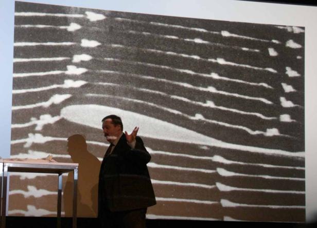 Ein Mann präsentiert eine Visualisierung von Luftströmungen um ein Flugzeugprofil.