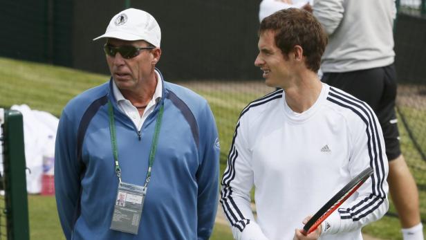 Ein Tennisspieler mit seinem Trainer auf dem Platz.