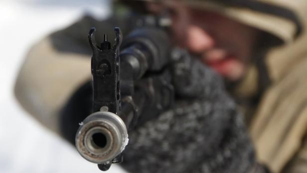 Ein Soldat zielt mit einem Gewehr in der Hand.