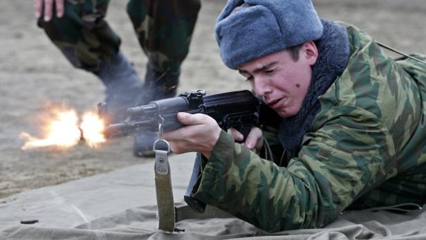 Ein Soldat in Tarnkleidung feuert mit einem Sturmgewehr im Liegen.