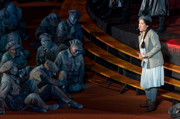 Guanqun Yu als Liù vor Statisten im Mao-Look.