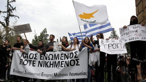 Menschen demonstrieren mit Flaggen und Transparenten in einer Straße.