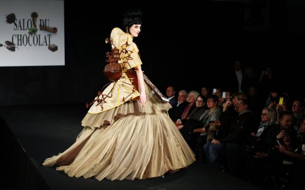 Eine Frau präsentiert ein Kleid aus Schokolade auf dem „Salon du Chocolat“.