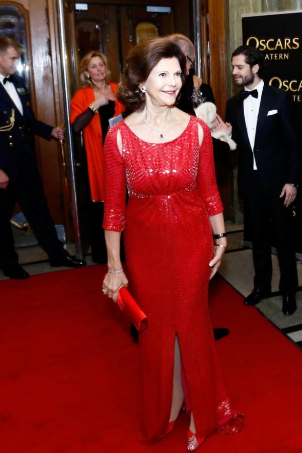 Königin Silvia von Schweden in einem roten Kleid auf dem roten Teppich.