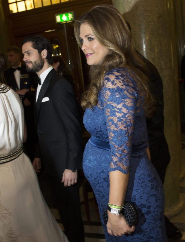 Prinzessin Madeleine von Schweden in einem blauen Spitzenkleid, begleitet von Prinz Carl Philip.