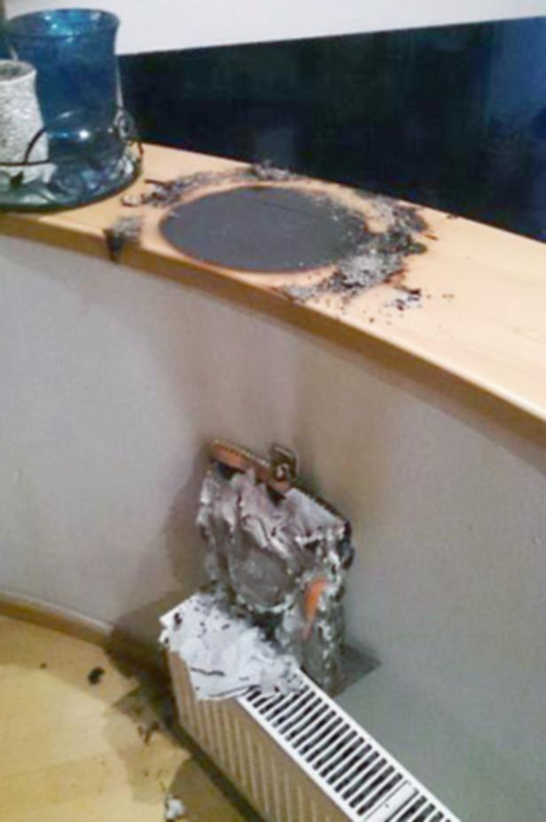 SALZBURG: BRENNENDER ADVENTKRANZ Ein verkohlter Bereich auf einem Holzbrett und Schäden an einer Wand und einem Heizkörper deuten auf einen Brand hin.