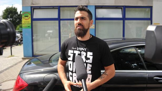 Bushido wird von Reportern vor einem schwarzen Auto interviewt.