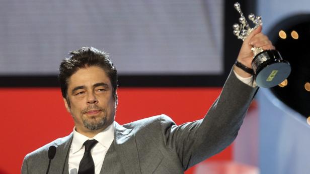 Benicio del Toro hält eine Trophäe in die Höhe.