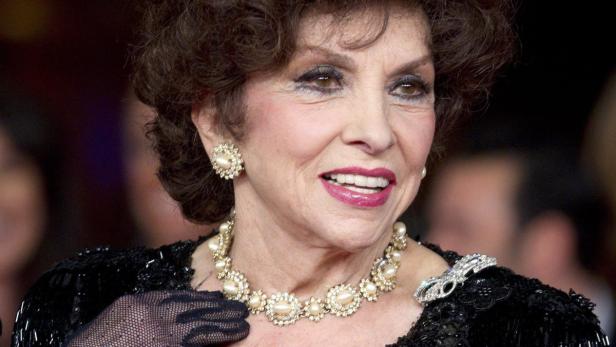 Gina Lollobrigida mit Perlenkette und Ohrringen bei einer Veranstaltung.