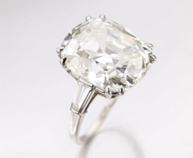 Ein Ring mit einem großen, quadratischen Diamanten auf einem silbernen Band.