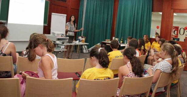 Eine Frau hält einen Vortrag vor einer Gruppe von Kindern.