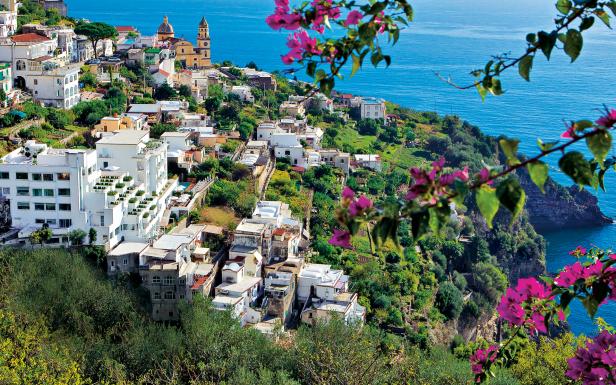 Blick auf die Küstenstadt Positano in Italien mit weiß getünchten Häusern und einer Kirche.