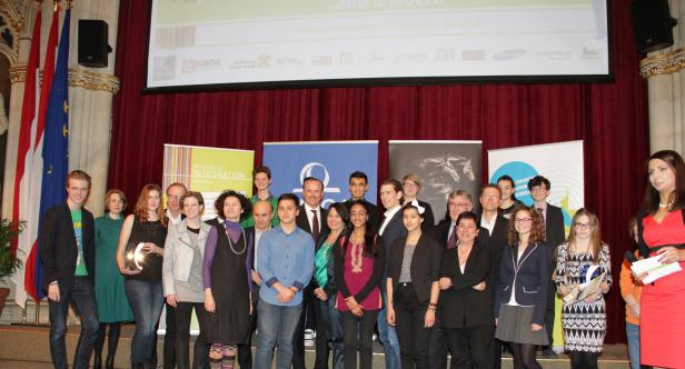 Eine Gruppe von Menschen steht auf einer Bühne bei einer Preisverleihung.