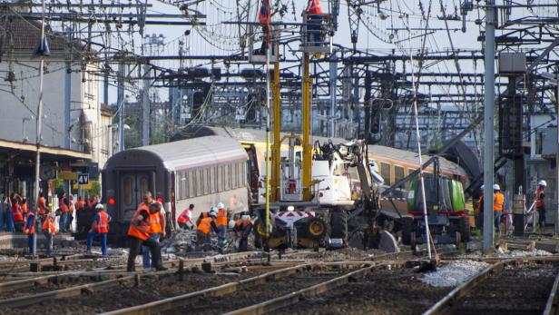 Ein Zugunglück mit Rettungskräften an einem Bahnhof.