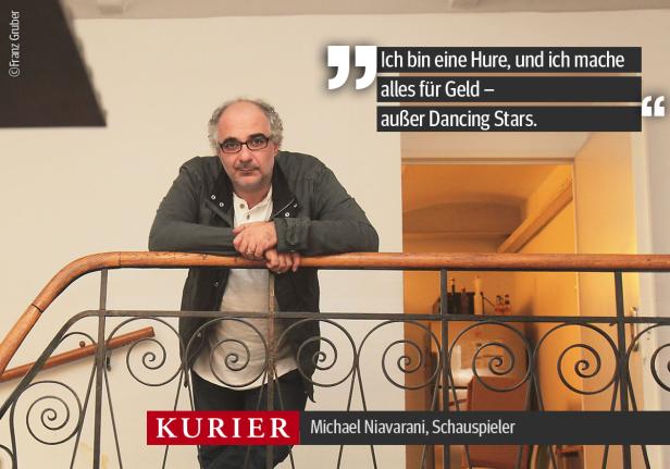 Der Schauspieler Michael Niavarani posiert an einem Treppengeländer.
