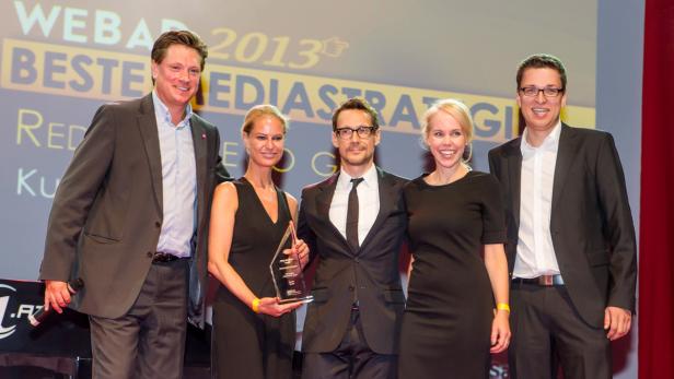 Eine Gruppe von fünf Personen posiert mit einer Auszeichnung vor einem Bildschirm mit der Aufschrift „WEBAR 2013“. Eine Gruppe von fünf Personen posiert mit einer Auszeichnung vor einem Bildschirm mit der Aufschrift „WEBAR 2013“.