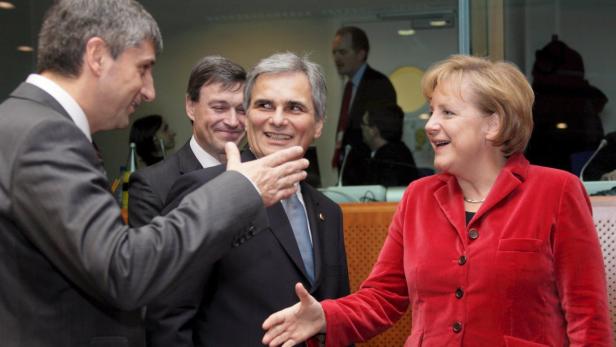 Angela Merkel begrüßt andere Politiker mit einem Händedruck.