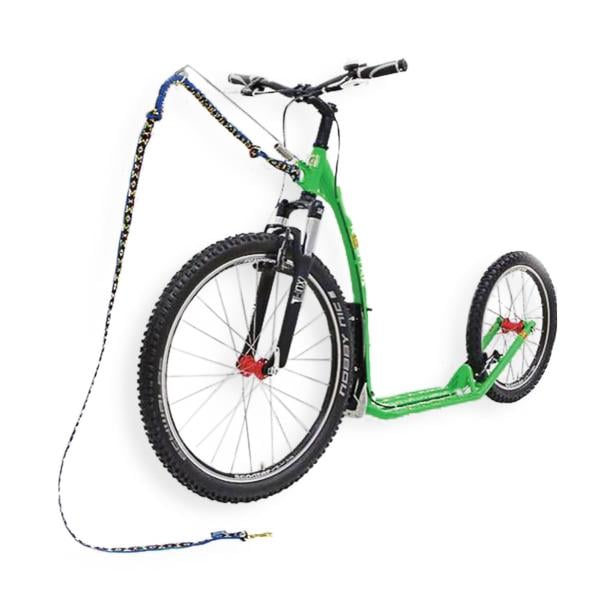 Ein grüner Tretroller mit großen Reifen und einer bunten Zugschnur.