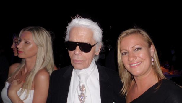 Karl Lagerfeld posiert mit zwei blonden Frauen für ein Foto.