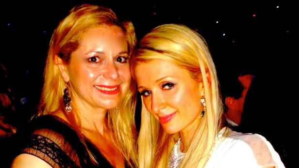 Paris Hilton posiert mit einer Frau für ein Foto.