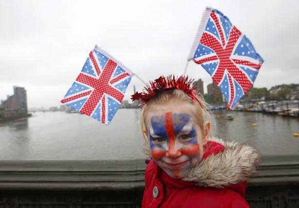 Ein Mädchen mit aufgemaltem Union Jack und zwei kleinen Großbritannien-Flaggen auf dem Kopf.