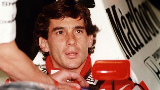 Ayrton Senna sitzt im Cockpit seines Rennwagens.