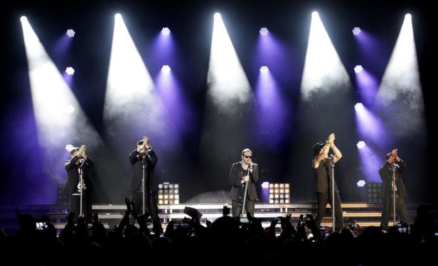 Eine Band tritt auf einer Bühne vor einem Publikum auf.