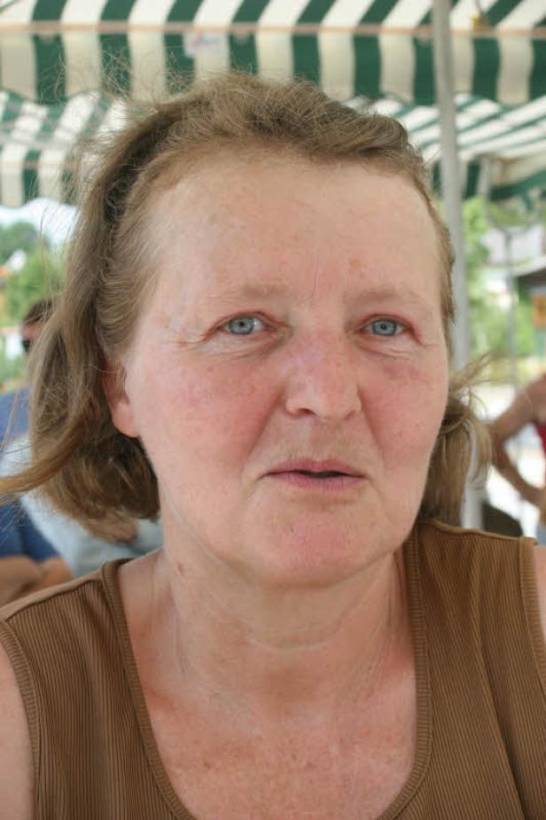 Porträt einer Frau mit braunen Haaren und blau-grauen Augen.