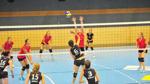 Volleyballspielerinnen während eines Spiels am Netz.