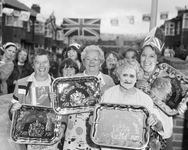 Eine Gruppe von Frauen hält Tabletts zum silbernen Thronjubiläum der Queen im Jahr 1977.